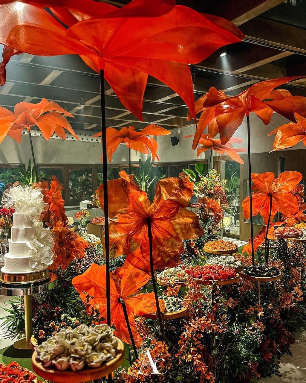 Fleurs géantes en organza orange au-dessus de la table de desserts d'une fête des 15 ans à Rio de Janeiro