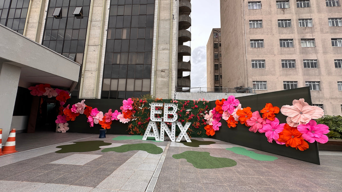 Muro de flores gigantes de papel crepé italiano con el letrero de EBANX