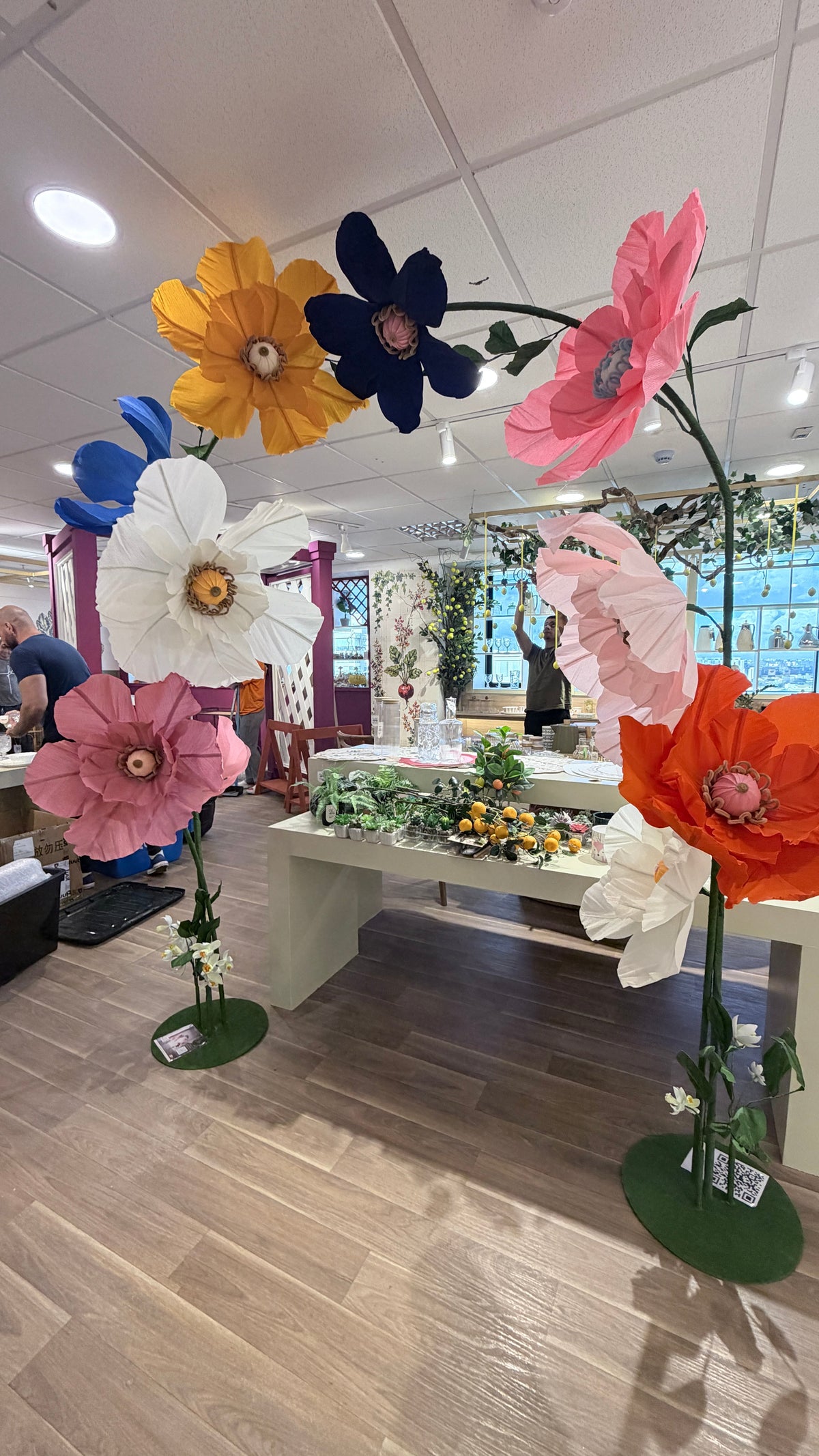 Arche de fleurs géantes colorées en papier crépon italien dans le showroom de Tutt Importadora