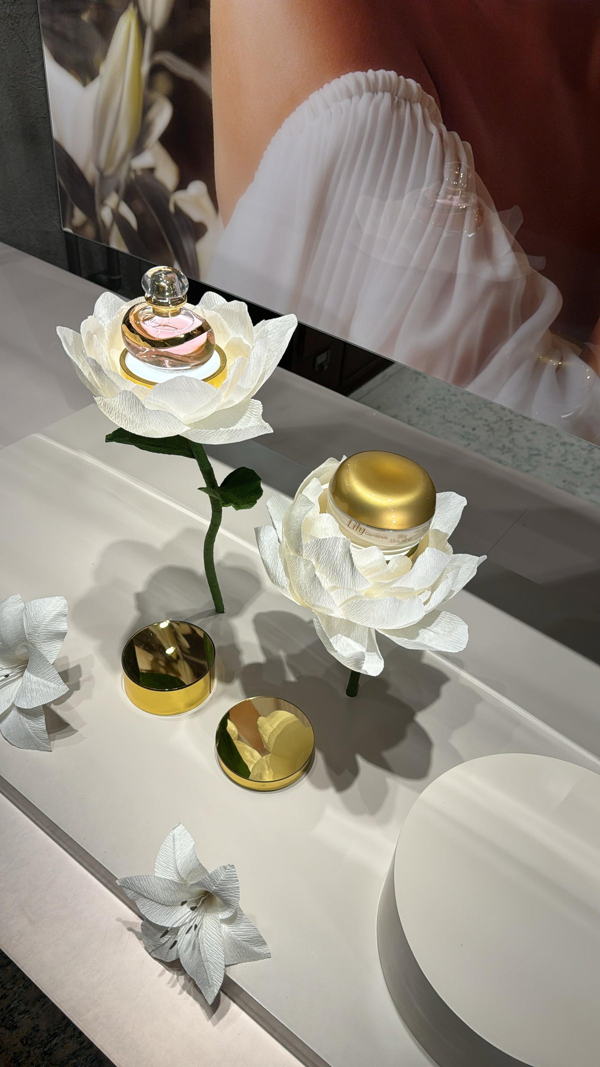 Lys géants en papier crépon italien soutenant les produits Lily Gardênia - O Boticário
