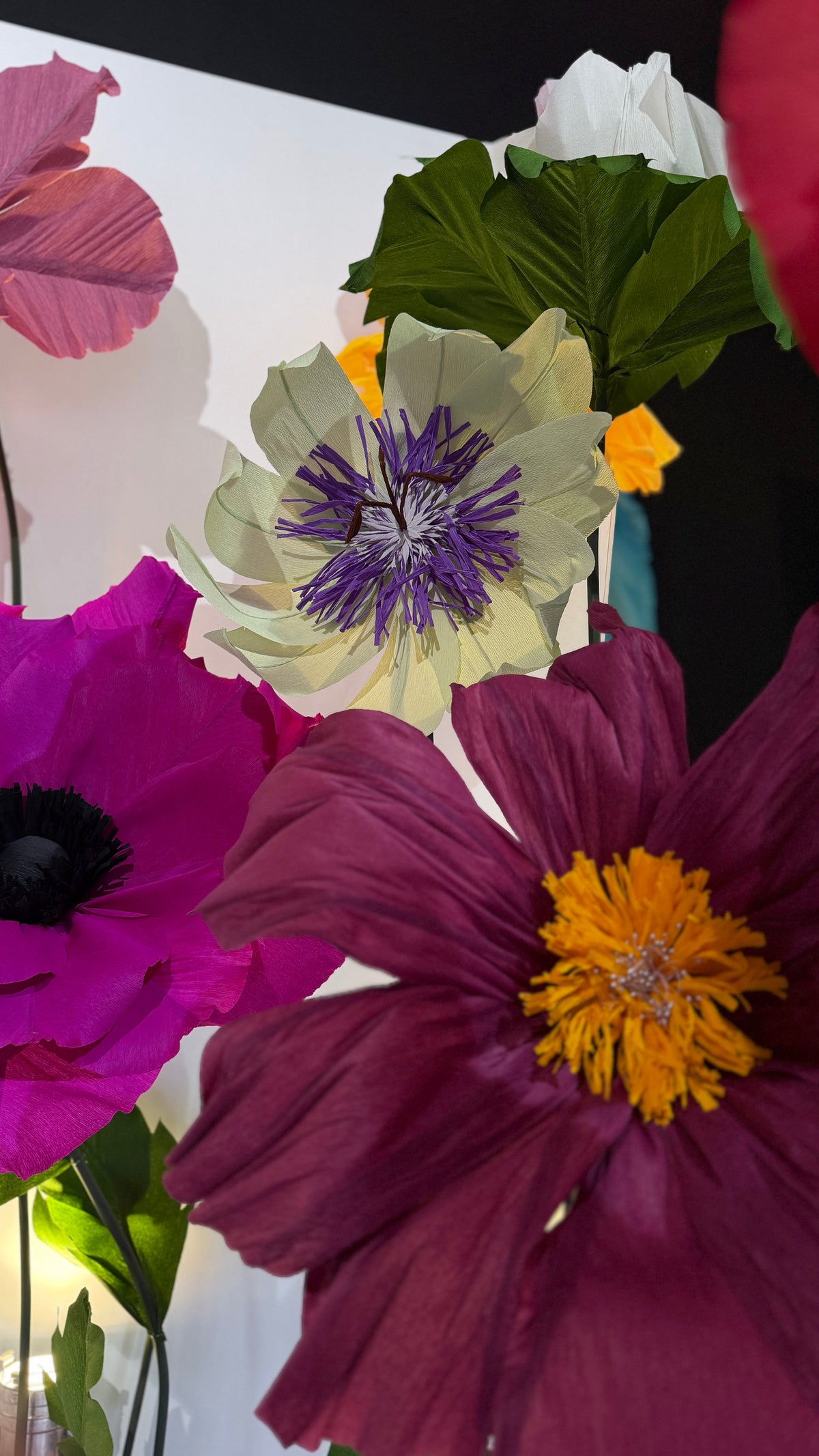 Flores gigantes de papel crepom italiano em magenta, vinho e lilás no evento Legado Mulheres