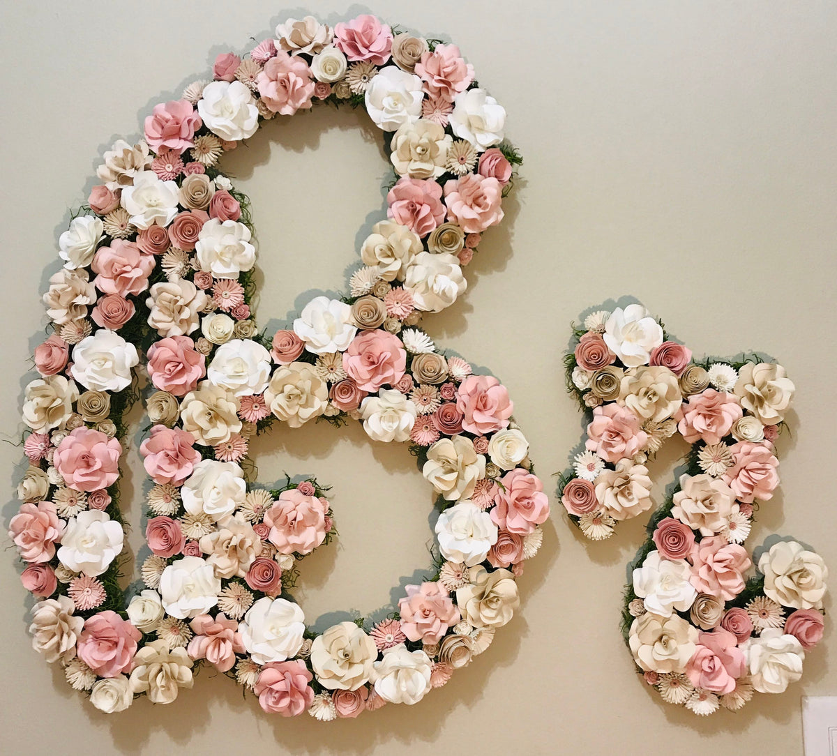 Br sign covered in pearlescent paper flowers on the store wall in Dallas