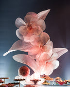 Sculpture de fleurs géantes en organza rosé, dans la décoration d'une fête des 15 ans