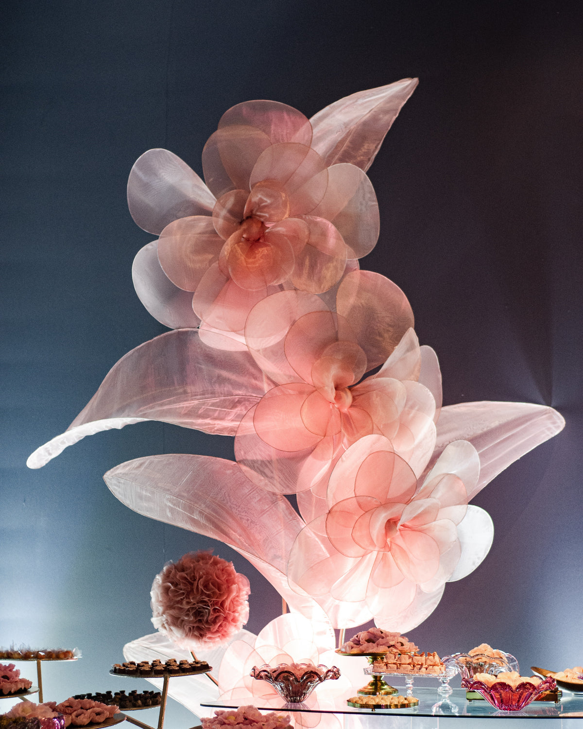 Sculpture de fleurs géantes en organza rosé, dans la décoration d'une fête des 15 ans
