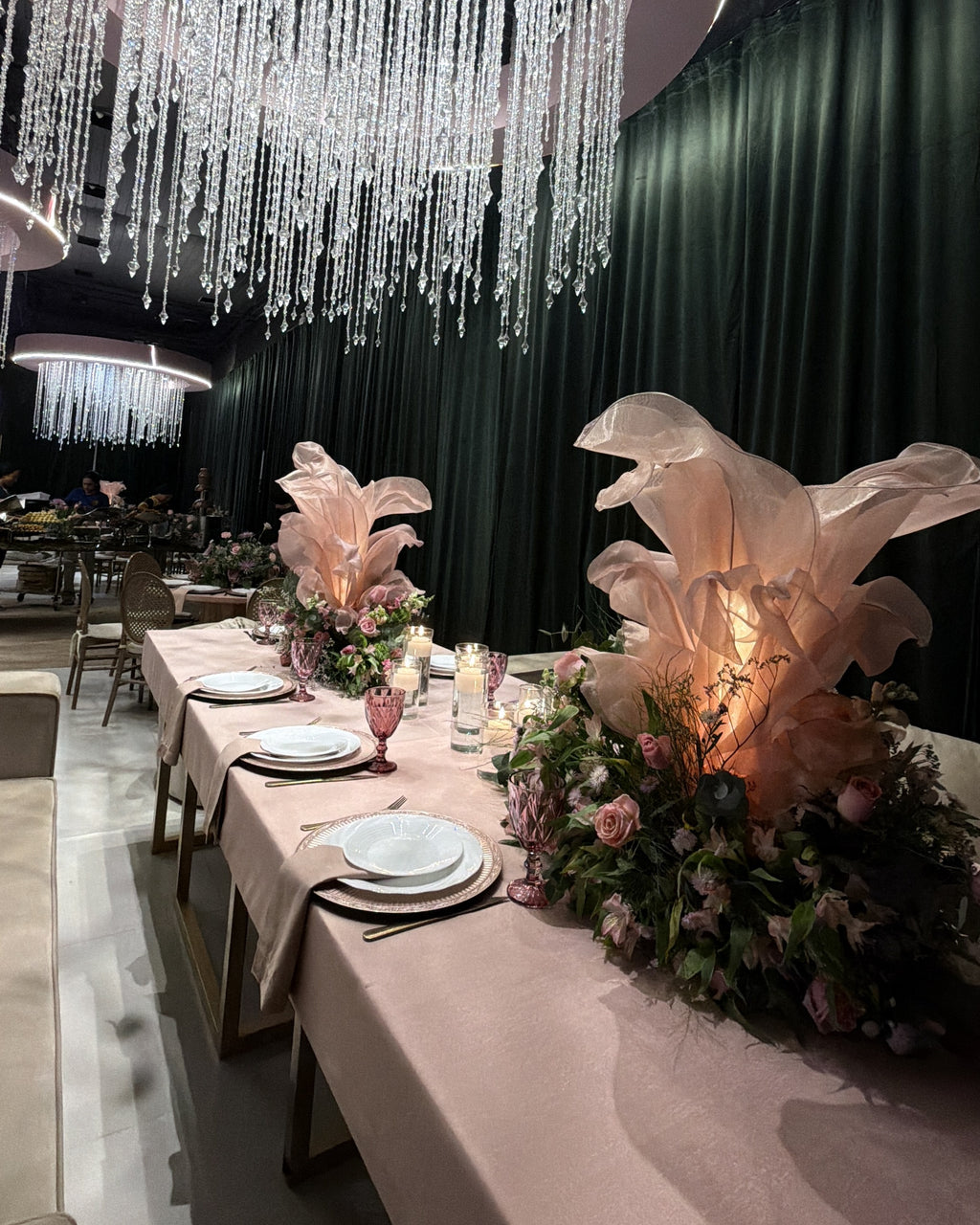 Flor gigante de organza iluminada, na mesa de um evento