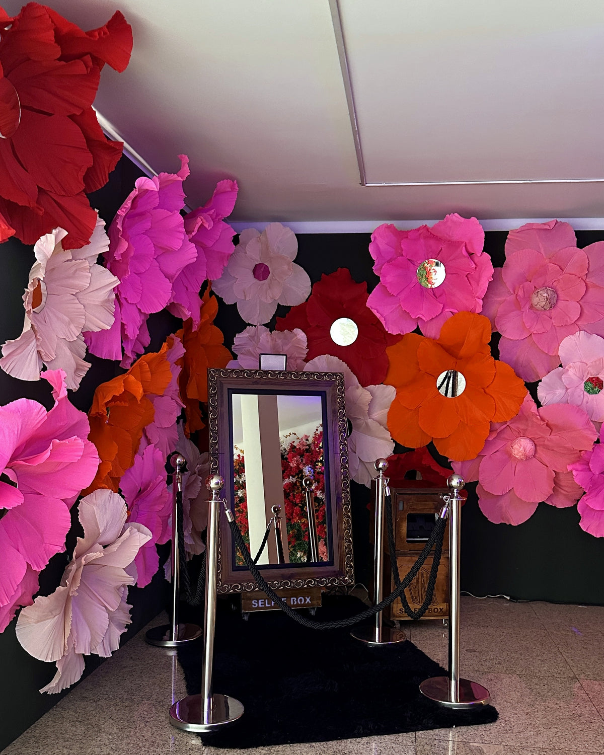 Flores gigantes de papel com miolo de espelho, no evento da Ebanx