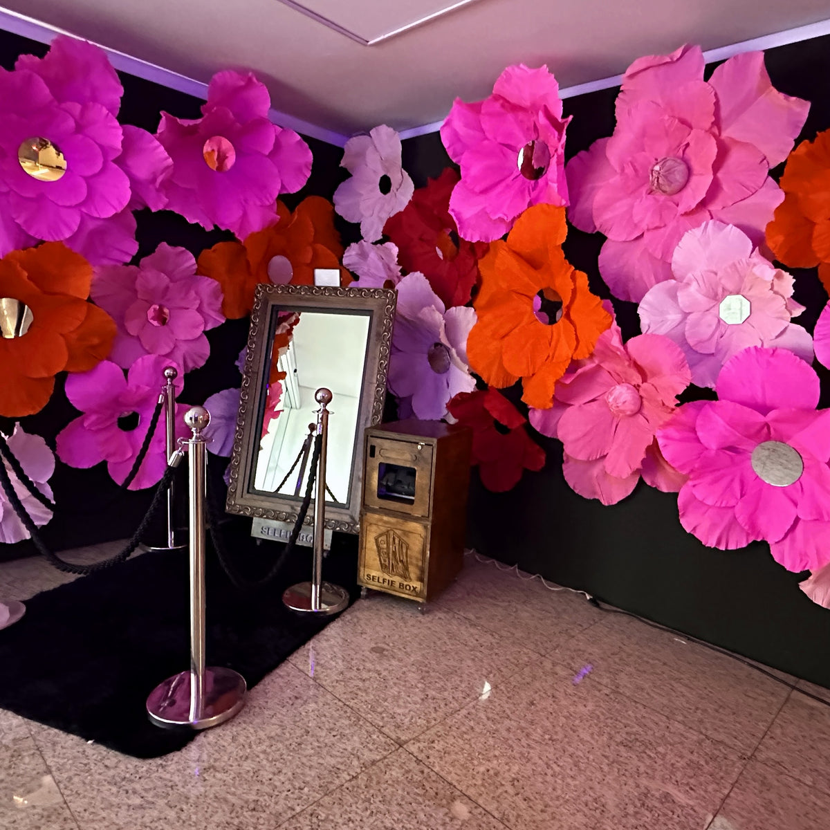 Flores gigantes de papel com miolo de espelho, no evento da Ebanx