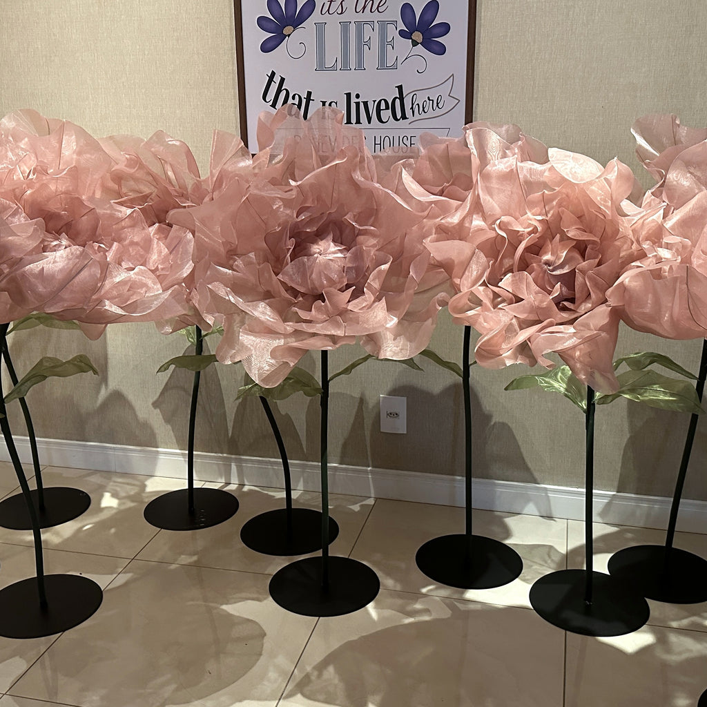 Row of large pink organza flowers on stands