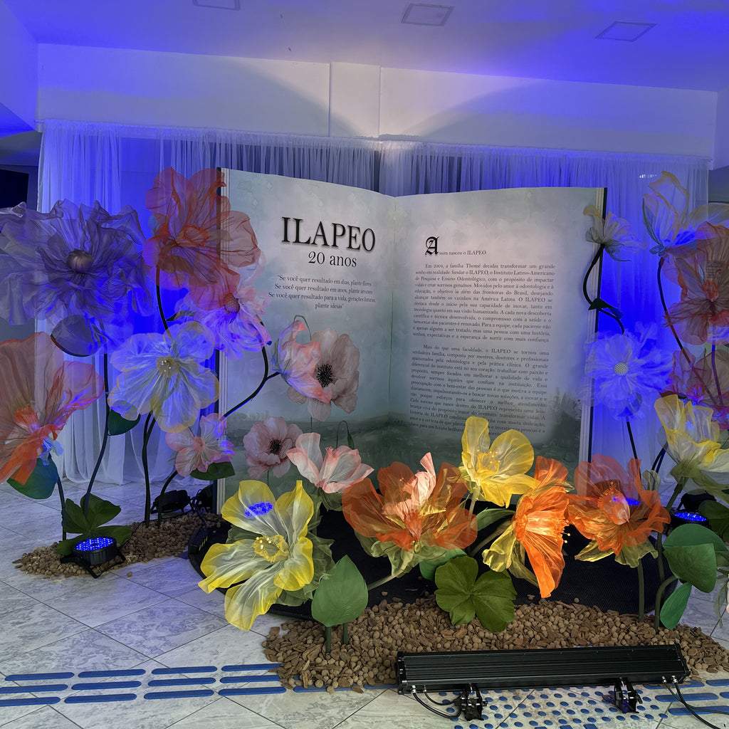 Flores gigantes de organza narciso na decoração do evento de 20 anos da ILAPEO