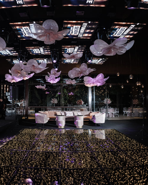 Flores gigantes de organza suspensas, sobre a pista de dança
