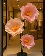 Fleurs géantes en papier crépon rosé à étamines, en vitrine