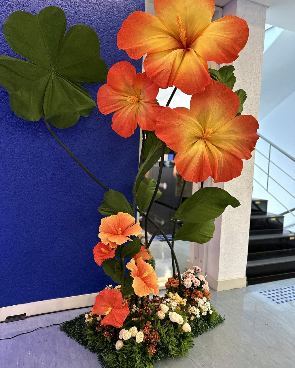 Hibiscos gigantes de papel crepom na decoração de evento