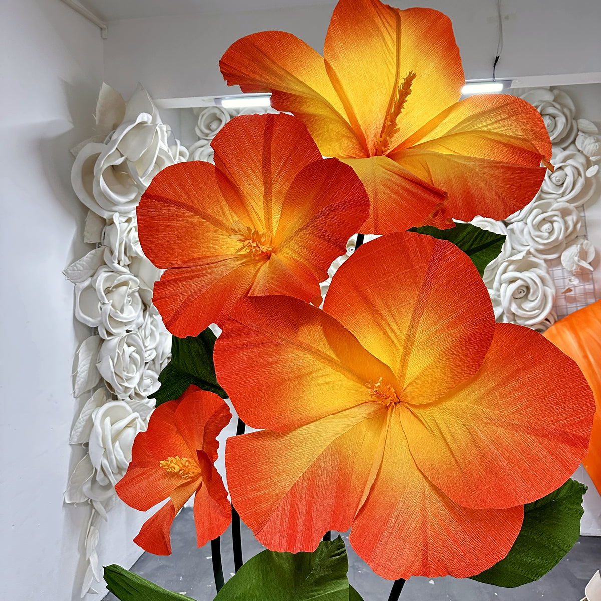 Flores gigantes de papel crepom: hibiscos laranja e amarelo