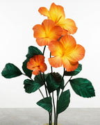 Pedestal com hibiscos gigantes de papel crepom italiano em degradê laranja e folhagem verde