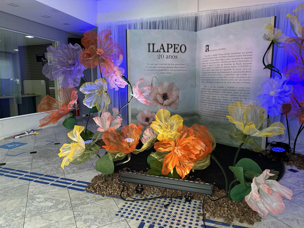 Giant scenic book beside the illuminated flowers - ILAPEO's 20th anniversary milestone