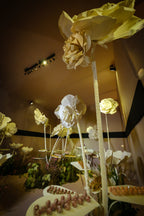 Low-angle view of the dessert room with giant EVA foam flowers and trays of sweets