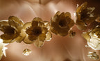 Close-up detail of layered giant flowers in gold tones — entrance corridor