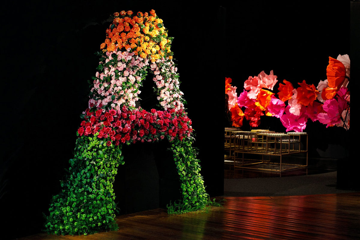 Debutante posing in front of the floral installation in warm tones