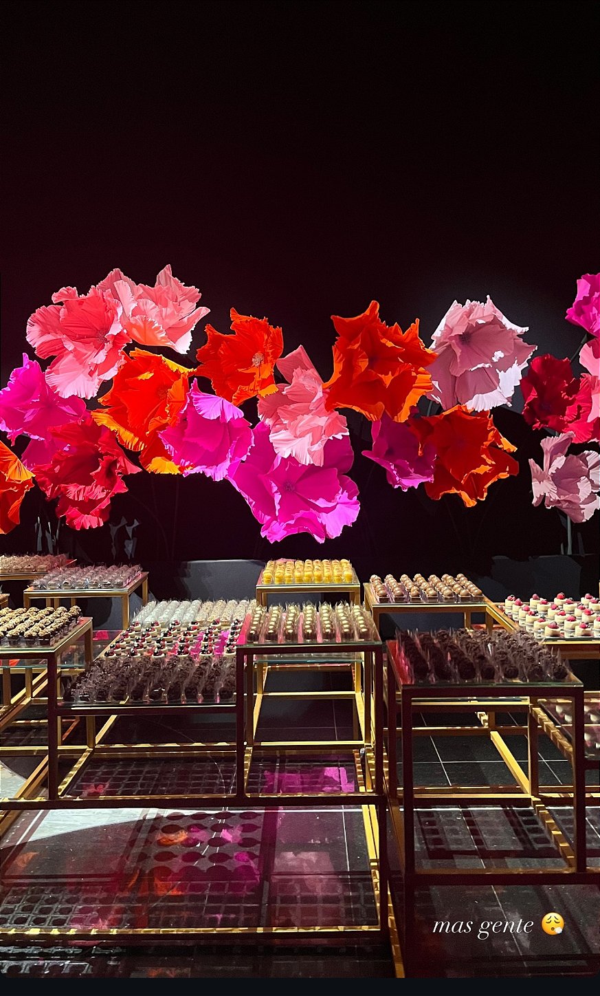 Guests interacting with the floral installation in warm tones