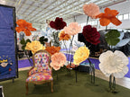 Sillón temático rodeado de flores gigantes en tonos cálidos