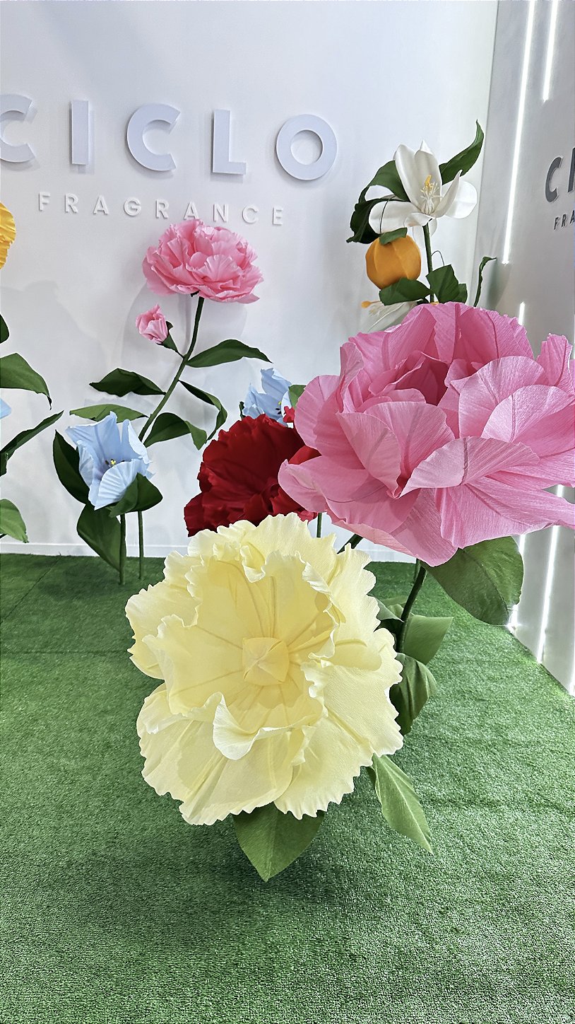 Visiteur interagissant avec les fleurs géantes sur le stand de Ciclo