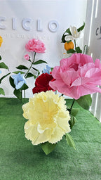 Visiteur interagissant avec les fleurs géantes sur le stand de Ciclo