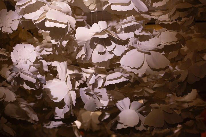 Immersive corridor with a suspended rain of white flowers - guest pathway