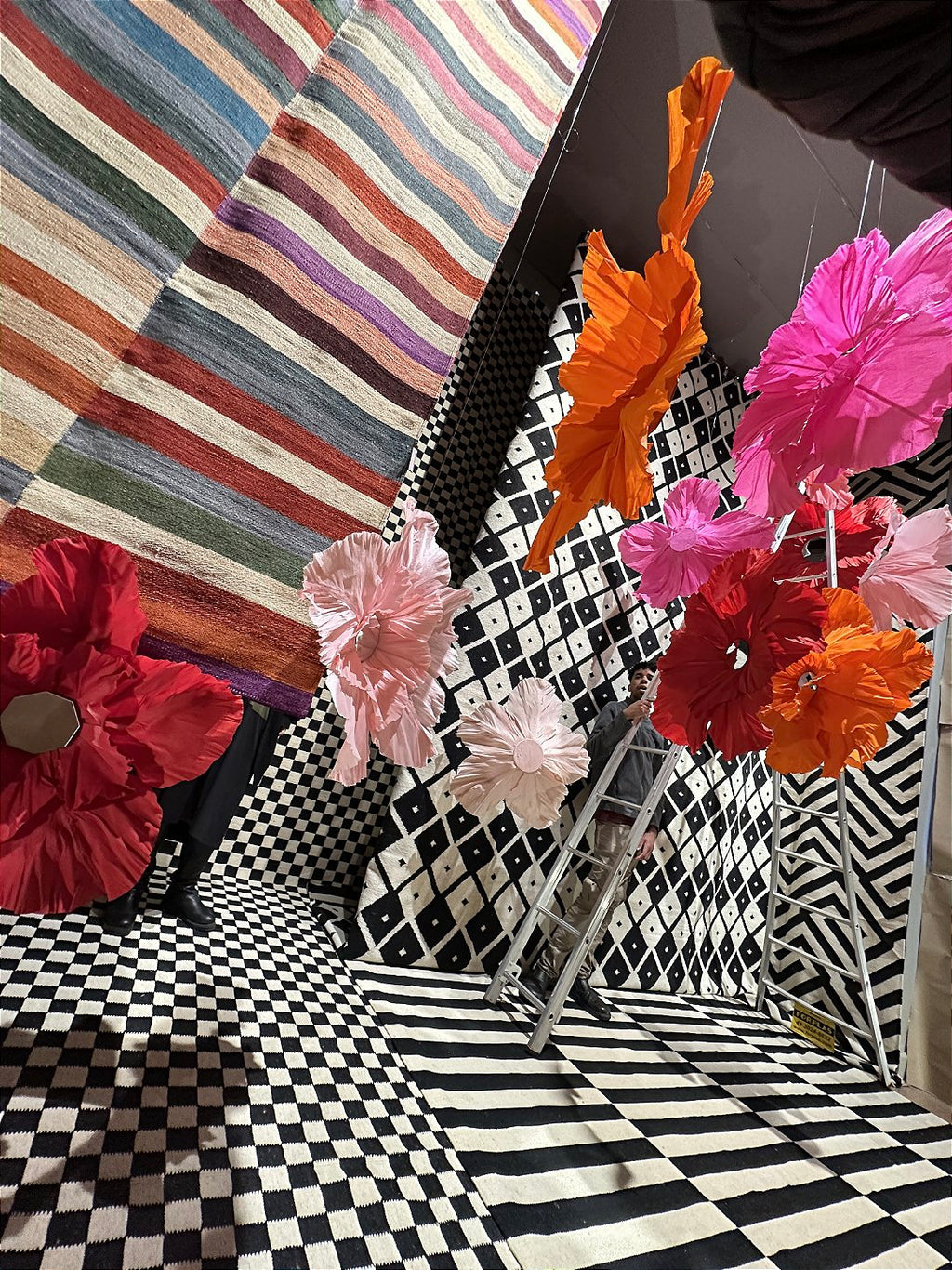 Pedestrians admiring the storefront decorated with suspended giant flowers