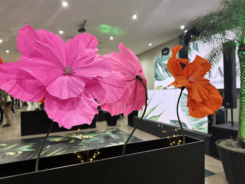 Giant EVA foam rose beside giant flowers in neon tones - Tropical Oasis installation