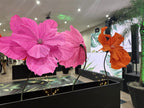 Giant EVA foam rose beside giant flowers in neon tones - Tropical Oasis installation