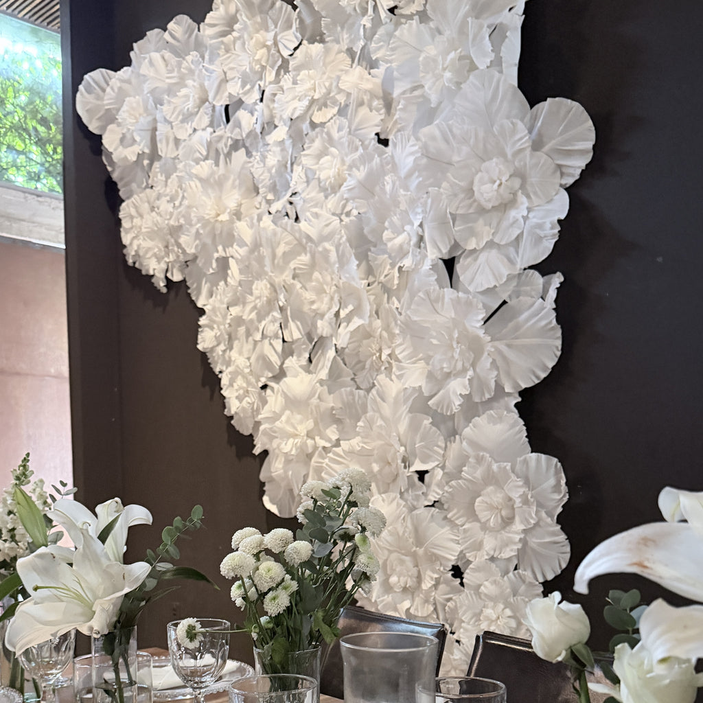Pared de flores gigantes de papel crepé marfil, en un evento