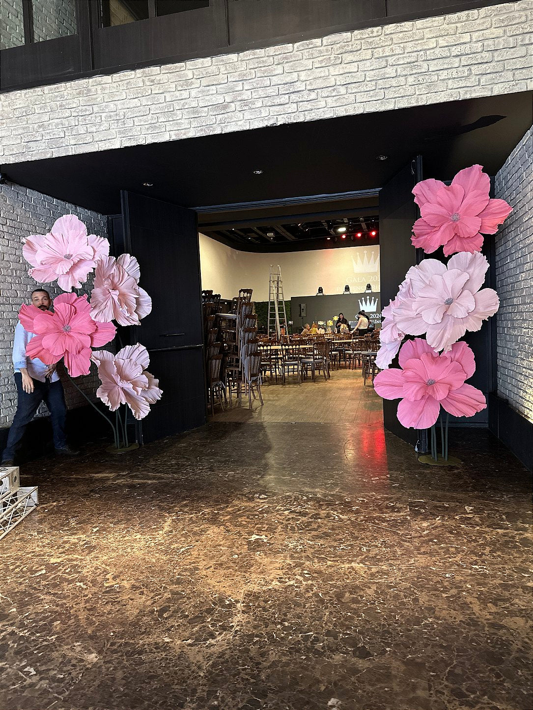 Botanical archway in giant Italian crepe paper flowers framing the entrance to the Pequeno Príncipe Gala