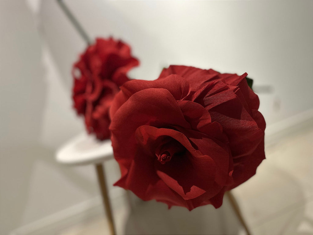 Giant rose beside the jewelry and handbags on display in the storefront