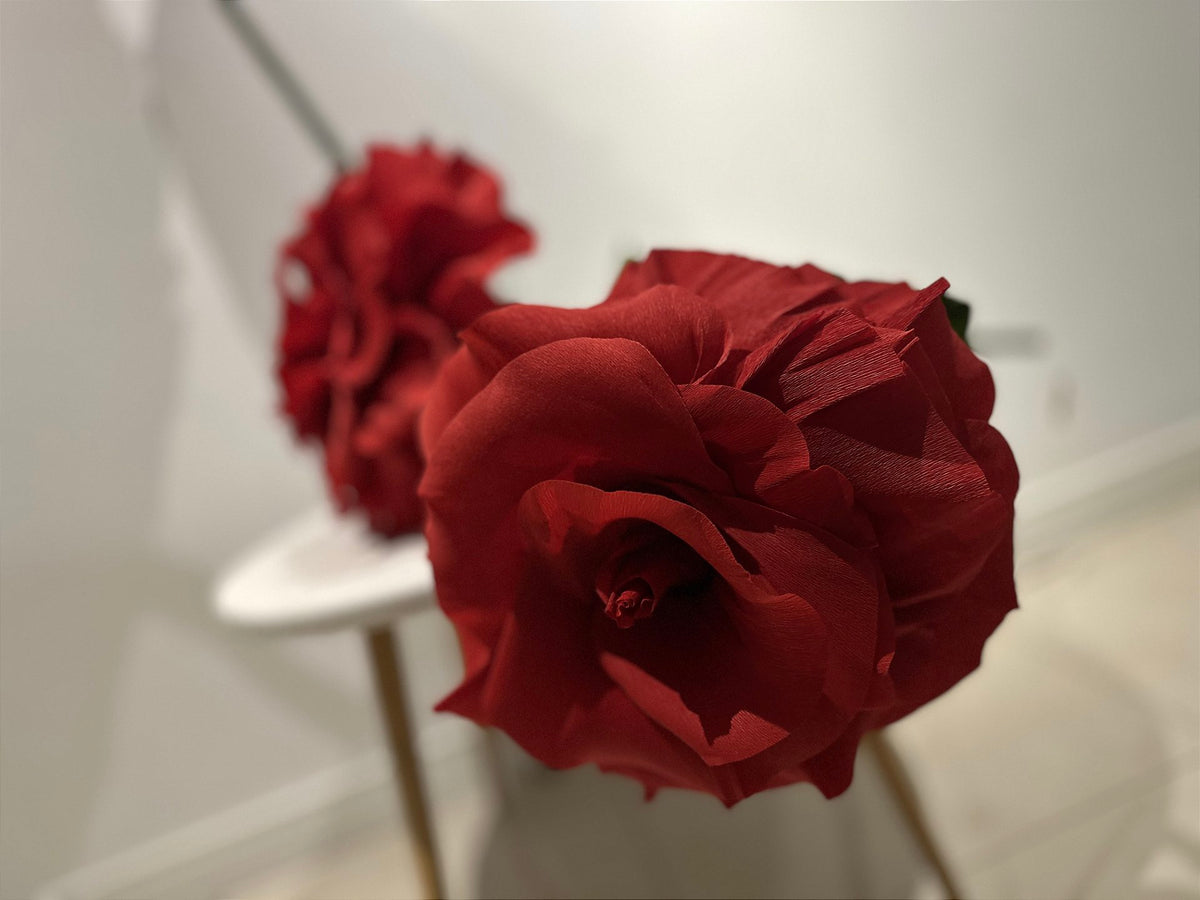 Giant rose beside the jewelry and handbags on display in the storefront