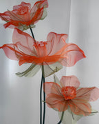 Trio of handcrafted organza daffodils on a decorative table